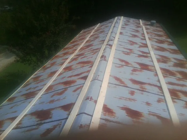 Rusted metal roof panels with new wood purlins before replacement — Storm Damage Roof Repair in Eatonton by Roofing Brothers