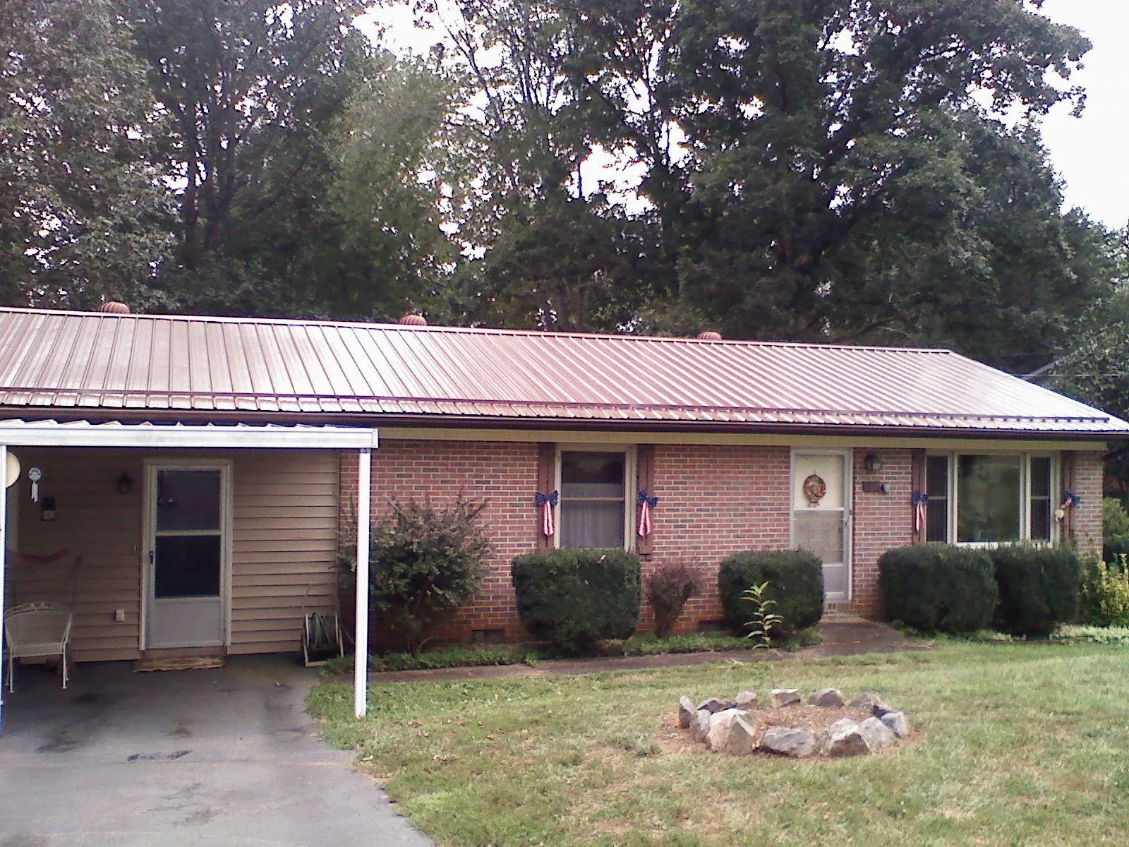 Bronze metal roof and carport on a brick ranch home — Roof Repair work by our crew in Eatonton